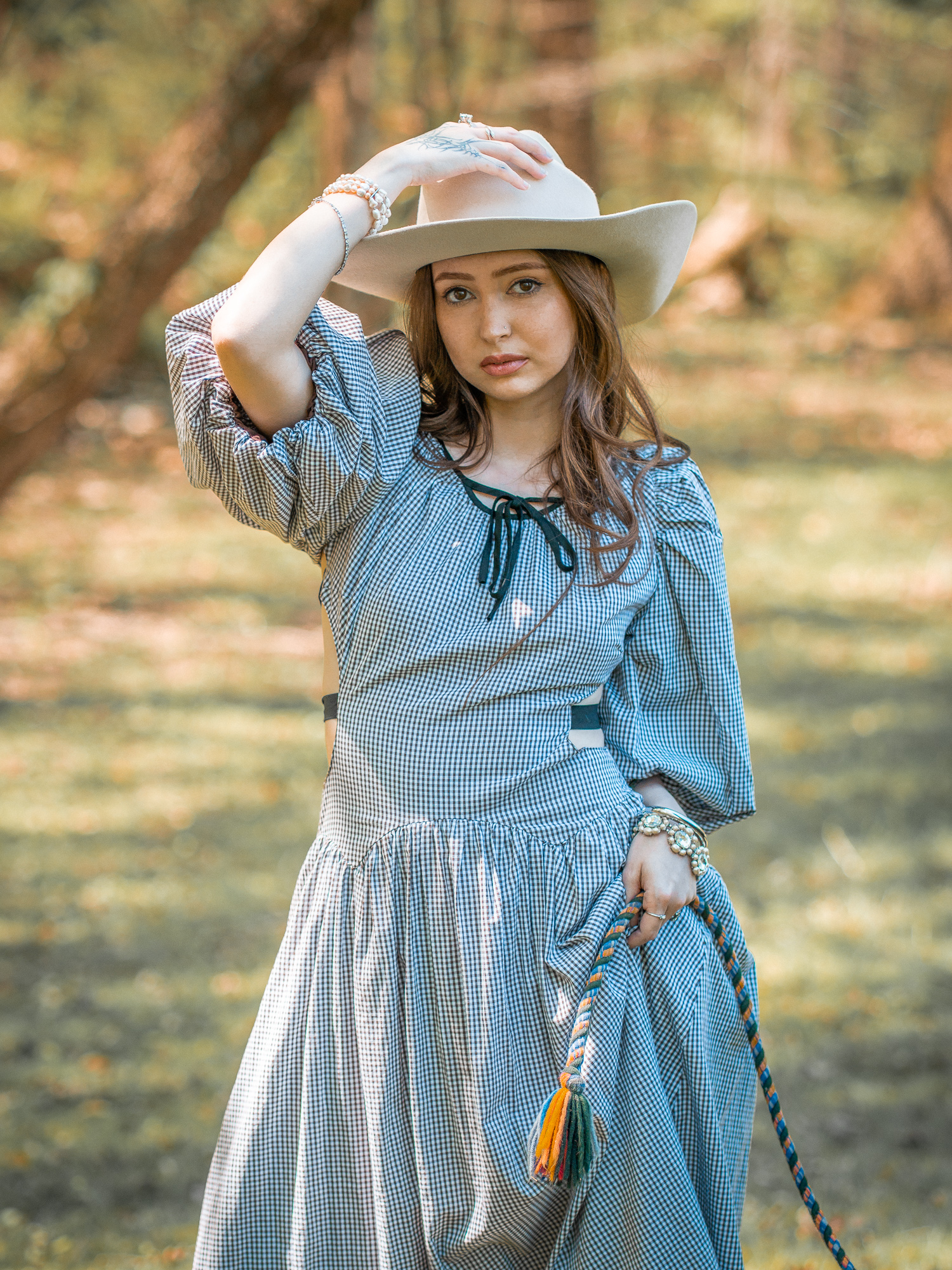 Mujer con sombrero blanco y vestido estampado azul al aire libre