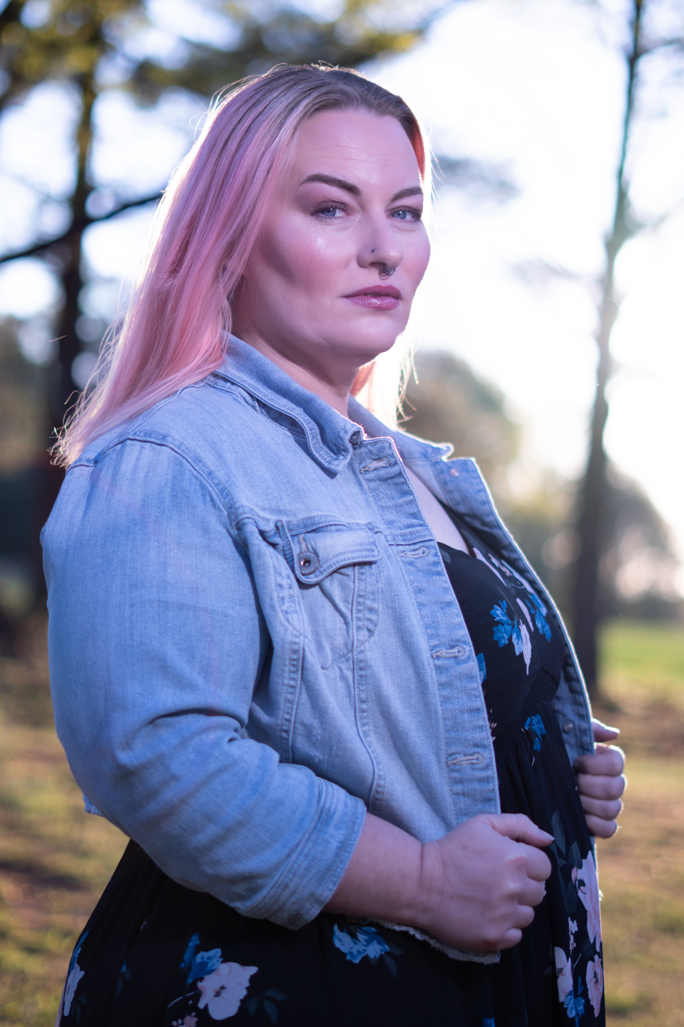 Retrato de mujer de cabello rosa con chaqueta de jean al atardecer